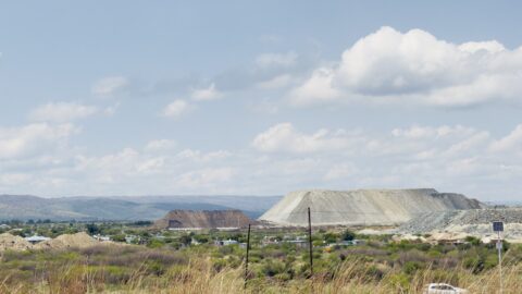 A large pile of platinum mining waste surges above the horizon in South Africa