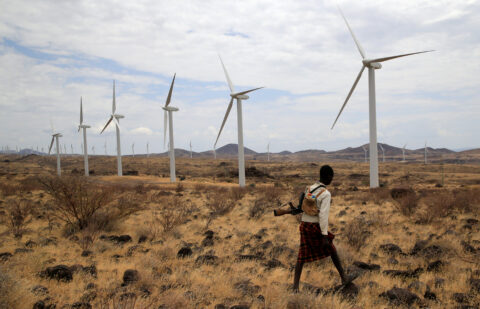 A Turkana herdboy carries his gun as he follows his goats near the power-generating wind turbines at the Lake Turkana Wind Power project (LTWP) in Loiyangalani district, Marsabit County, northern Kenya,