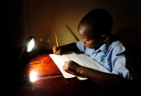 A boy doing homework by solar lantern