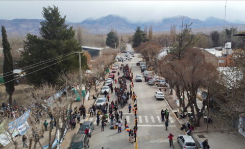 A drone view of protestors standing in the middle of a road which the glaciers in the background