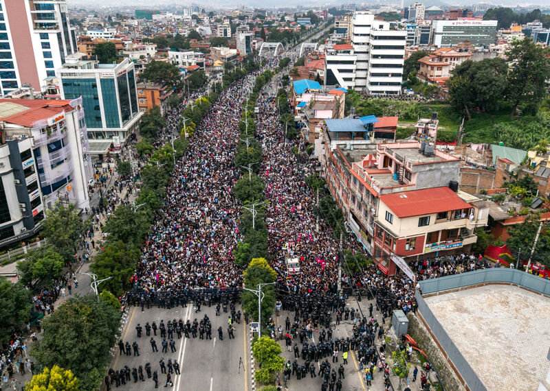 Aerial view of a large road reaching out into the distance filled with thousands of people. 