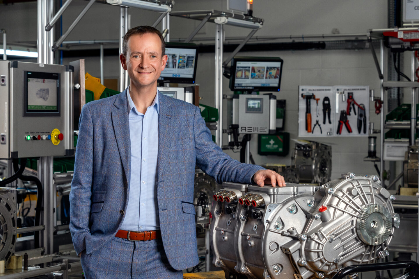 James Widmer stands with his hand on a rare easrth-free electric motor