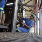 Mechanics work on a machine installed at Arcadia Lithium mine in Zimbabwe