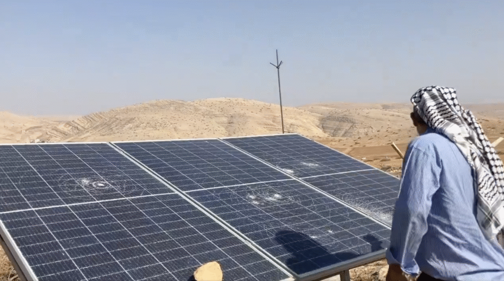 A man looks at a damaged solar panel